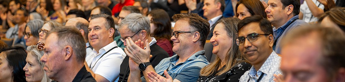 an audience reacts to a speaker on stage